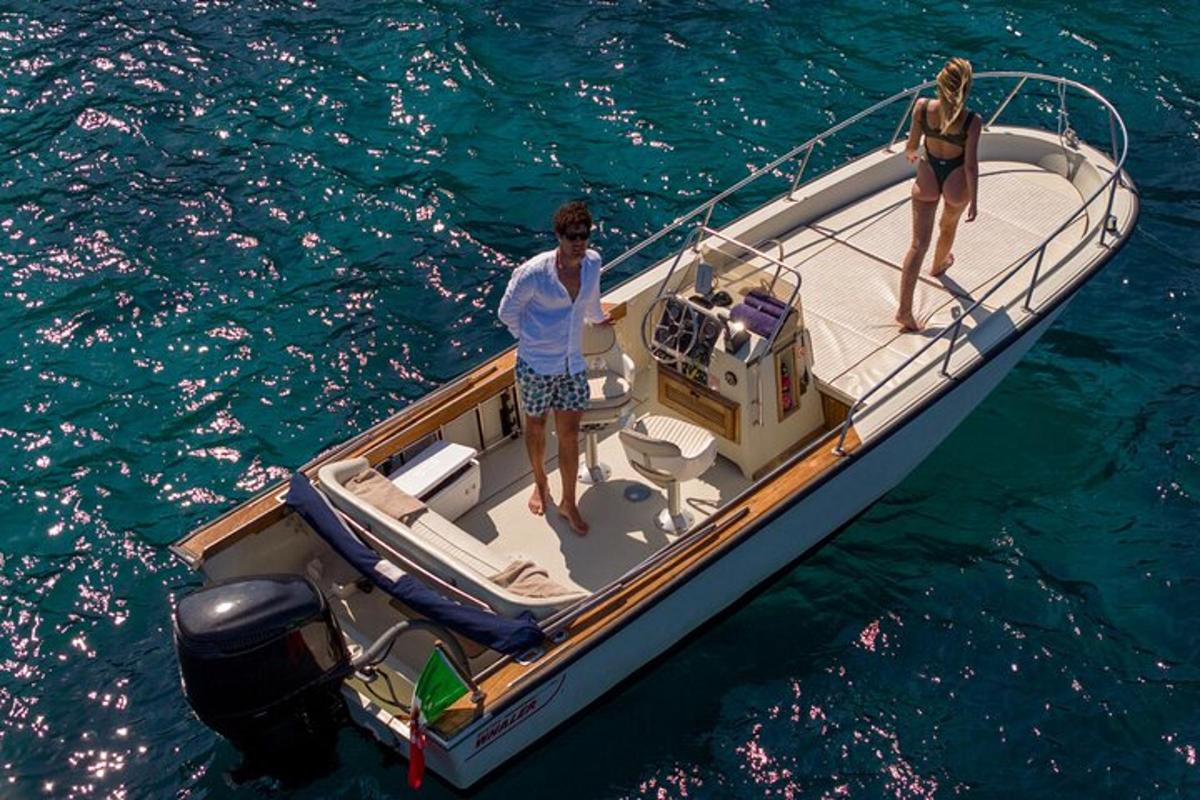 two people standing on a boat in the water