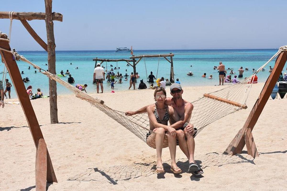 zwei Frauen sitzen in einer Hängematte am Strand