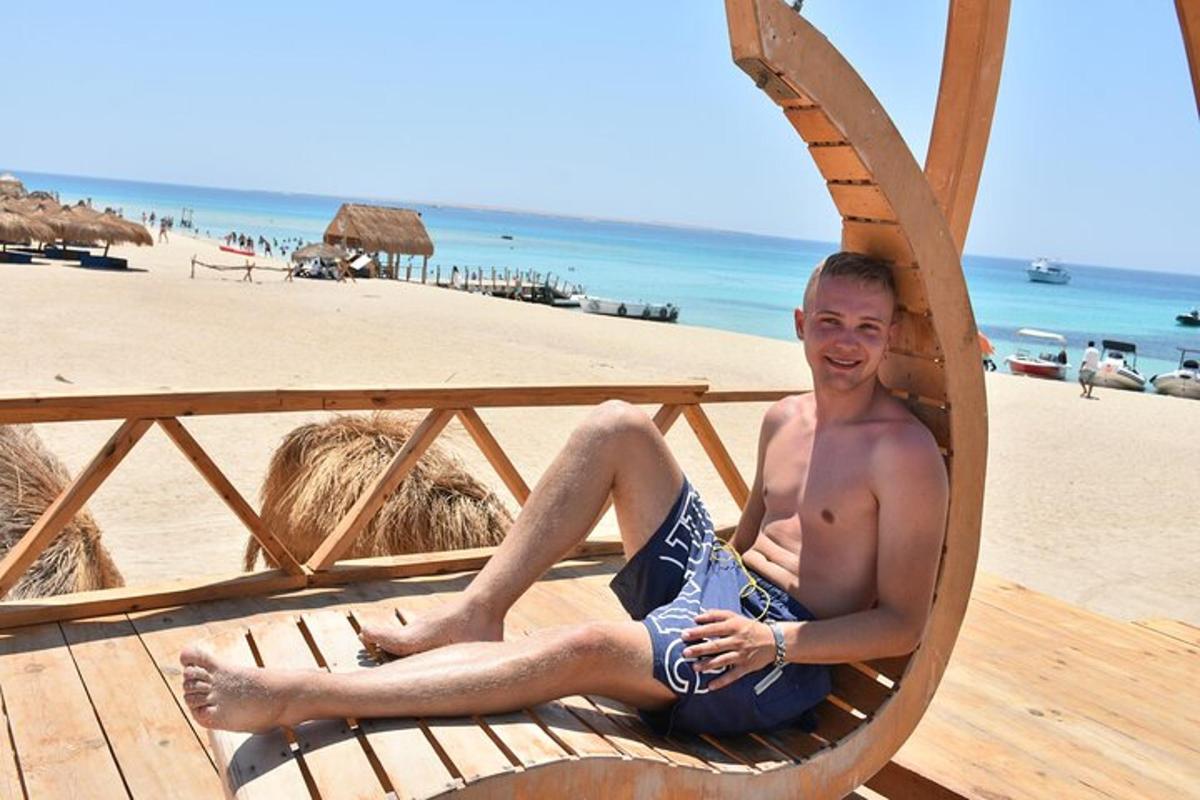un hombre sentado en una silla en la playa