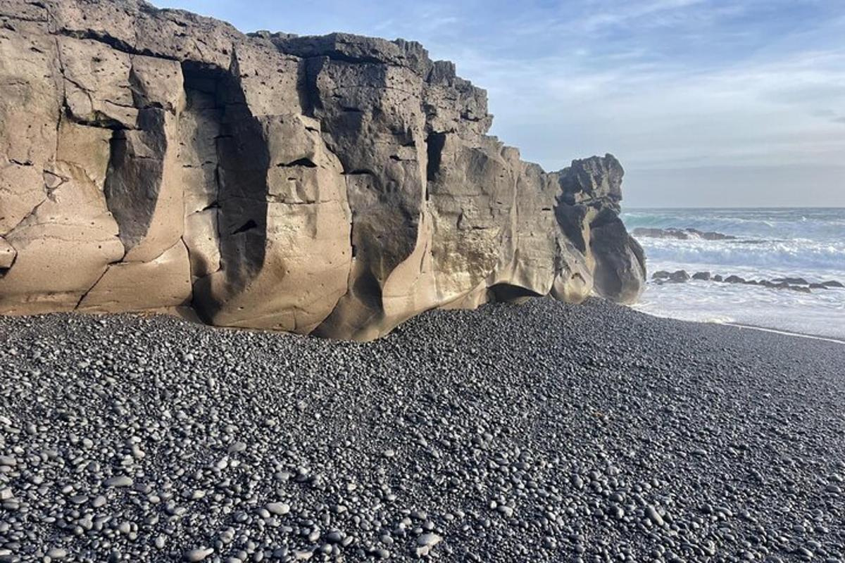 a beach with rocks and the ocean next to the ocean