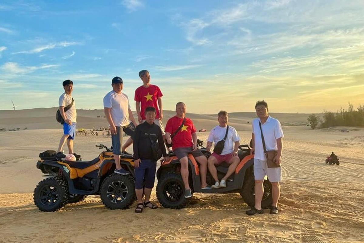 a group of people standing around a four wheeler on the beach