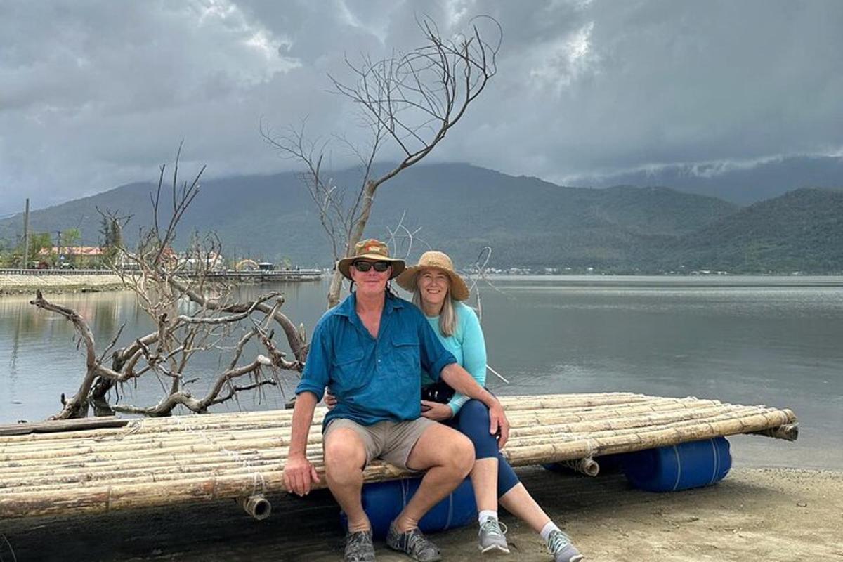 Un hombre y una mujer sentados en un tronco junto al agua