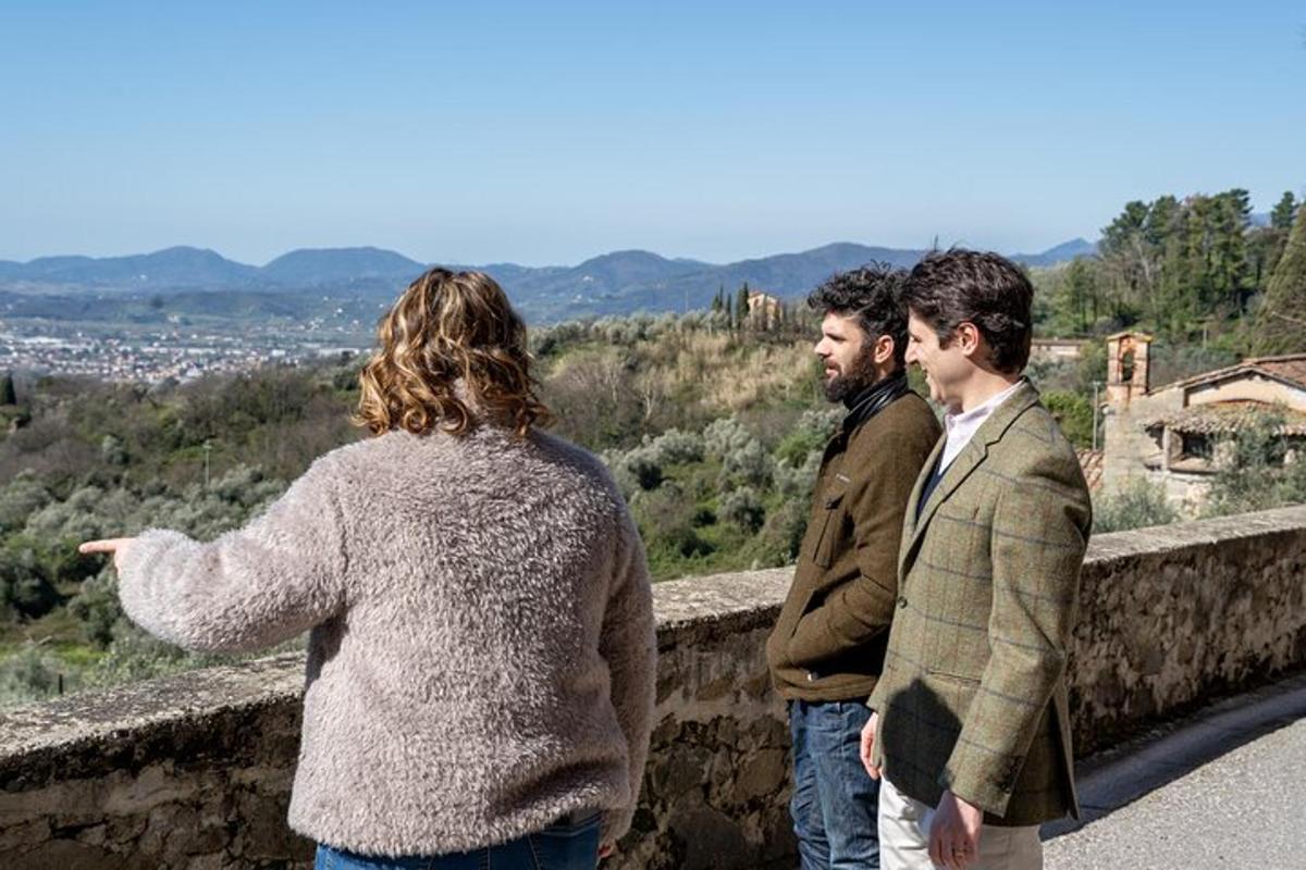 due uomini e una donna che guardano oltre un muro