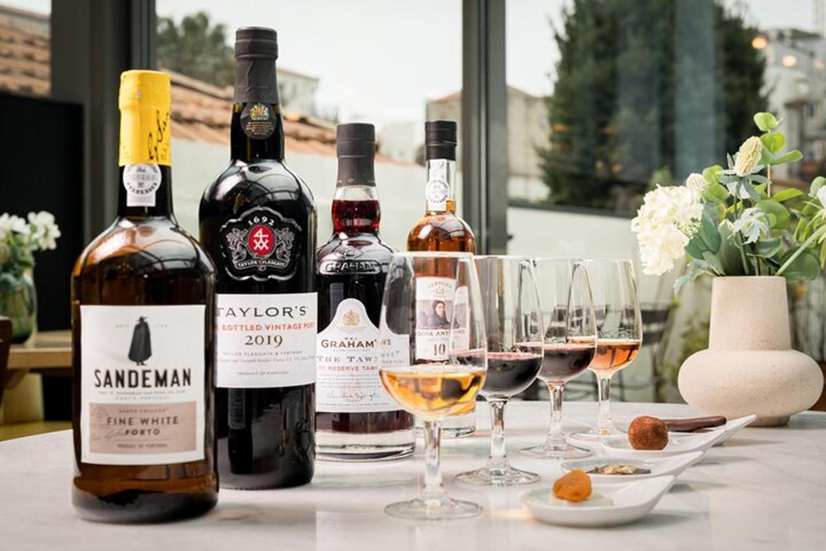 tre bottiglie di vino appoggiate su un tavolo con bicchieri da vino