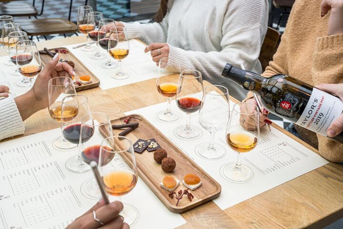 un gruppo di persone sedute a un tavolo con bicchieri di vino