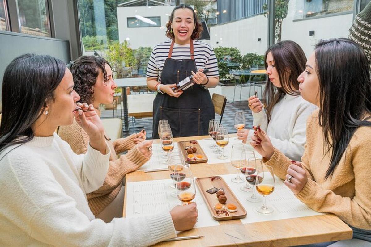 un gruppo di donne sedute attorno a un tavolo con bicchieri di vino