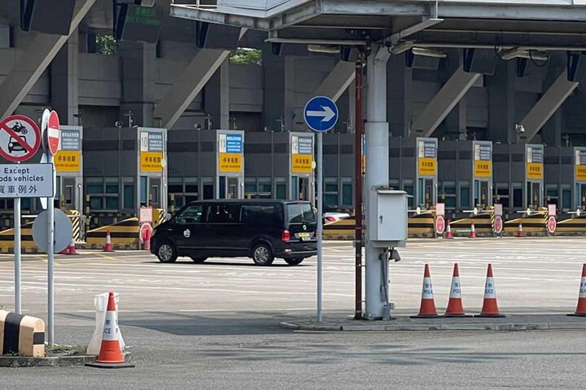 o dubă neagră parcată într-o parcare cu conuri portocalii