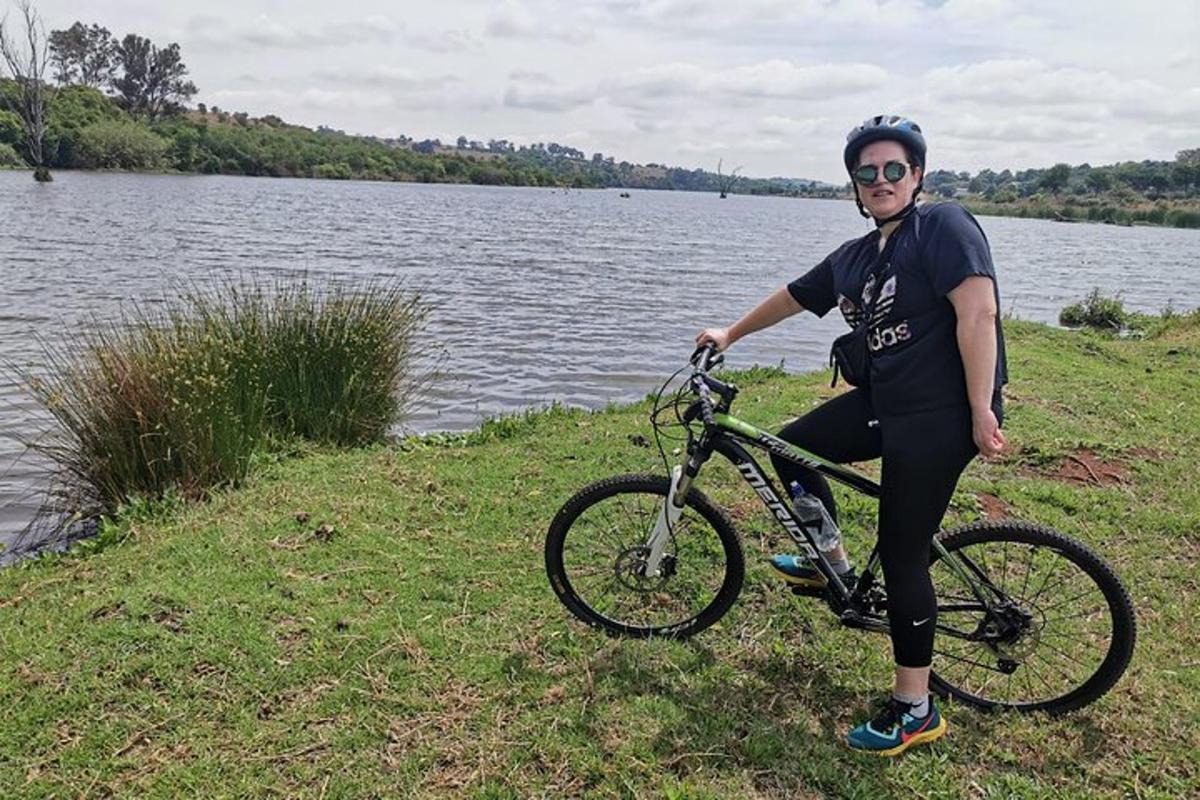 muž sediaci na bicykli pri jazere