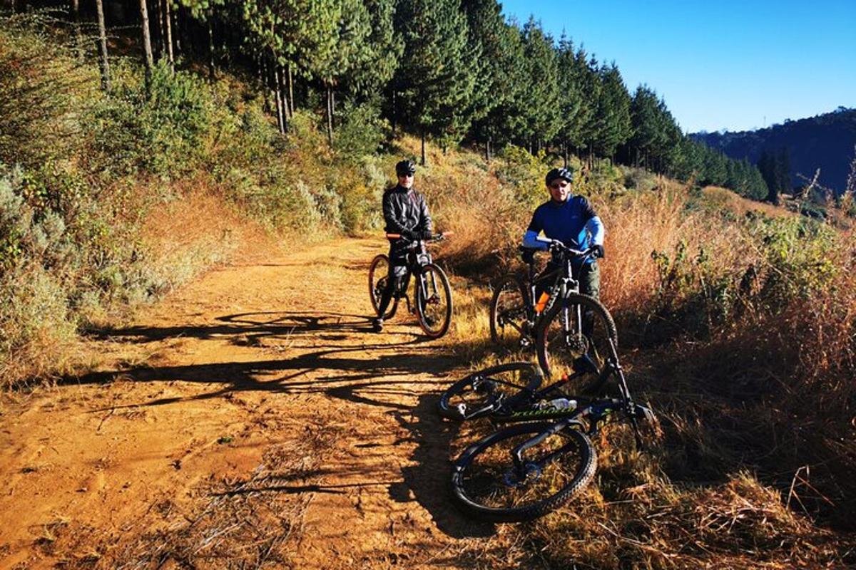 duas pessoas andando de bicicleta em uma estrada de terra