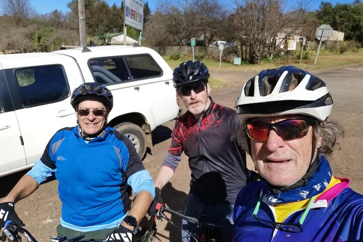 um grupo de três pessoas em bicicletas na frente de um carro