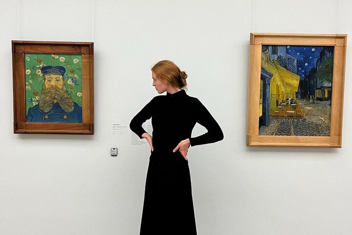 Una mujer con un vestido negro mirando un cuadro.