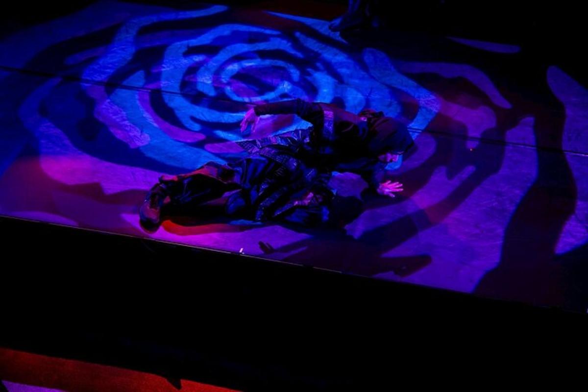 a person laying on a stage with purple lights