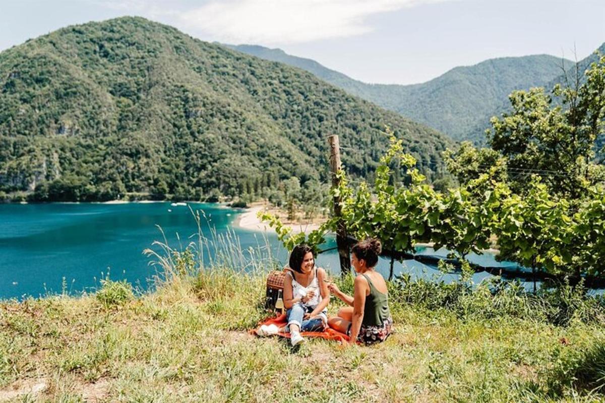 hai người ngồi trên một ngọn đồi bên cạnh một hồ nước