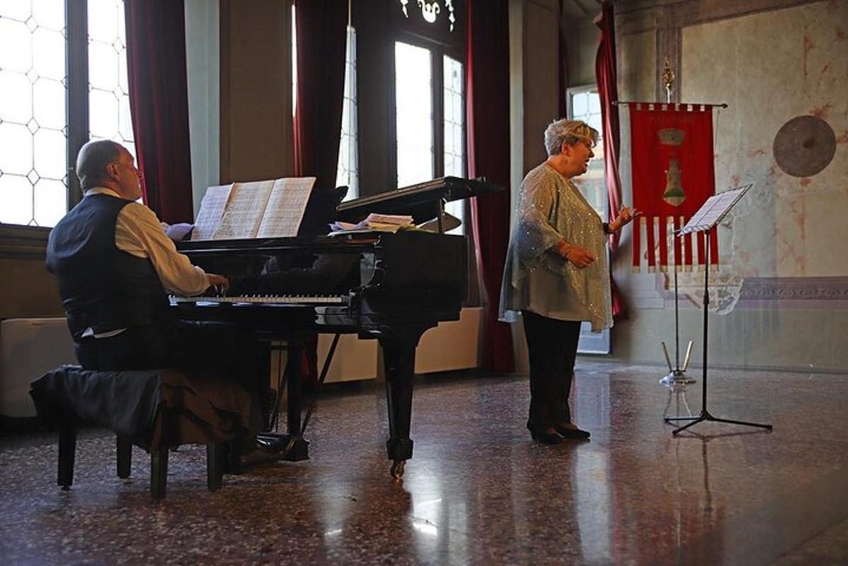 tveir einstaklingar standa í herbergi með píanó