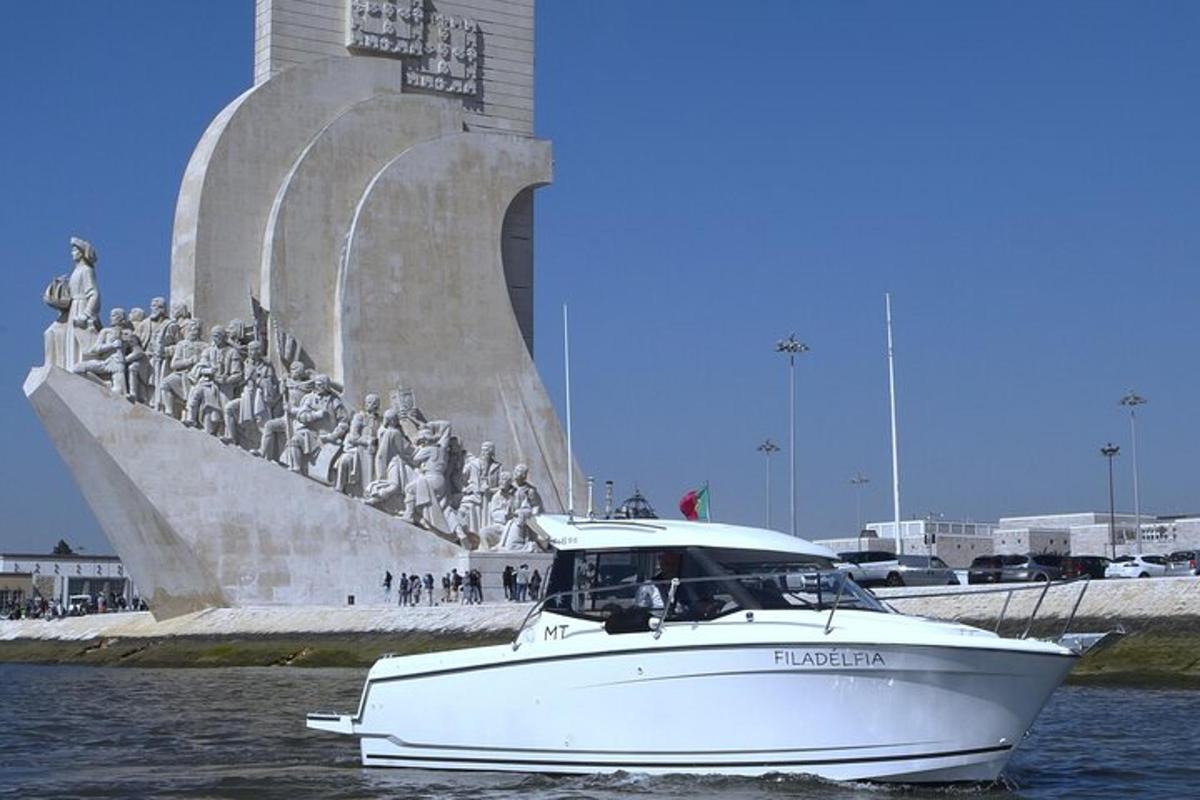 a white boat in the water near a statue
