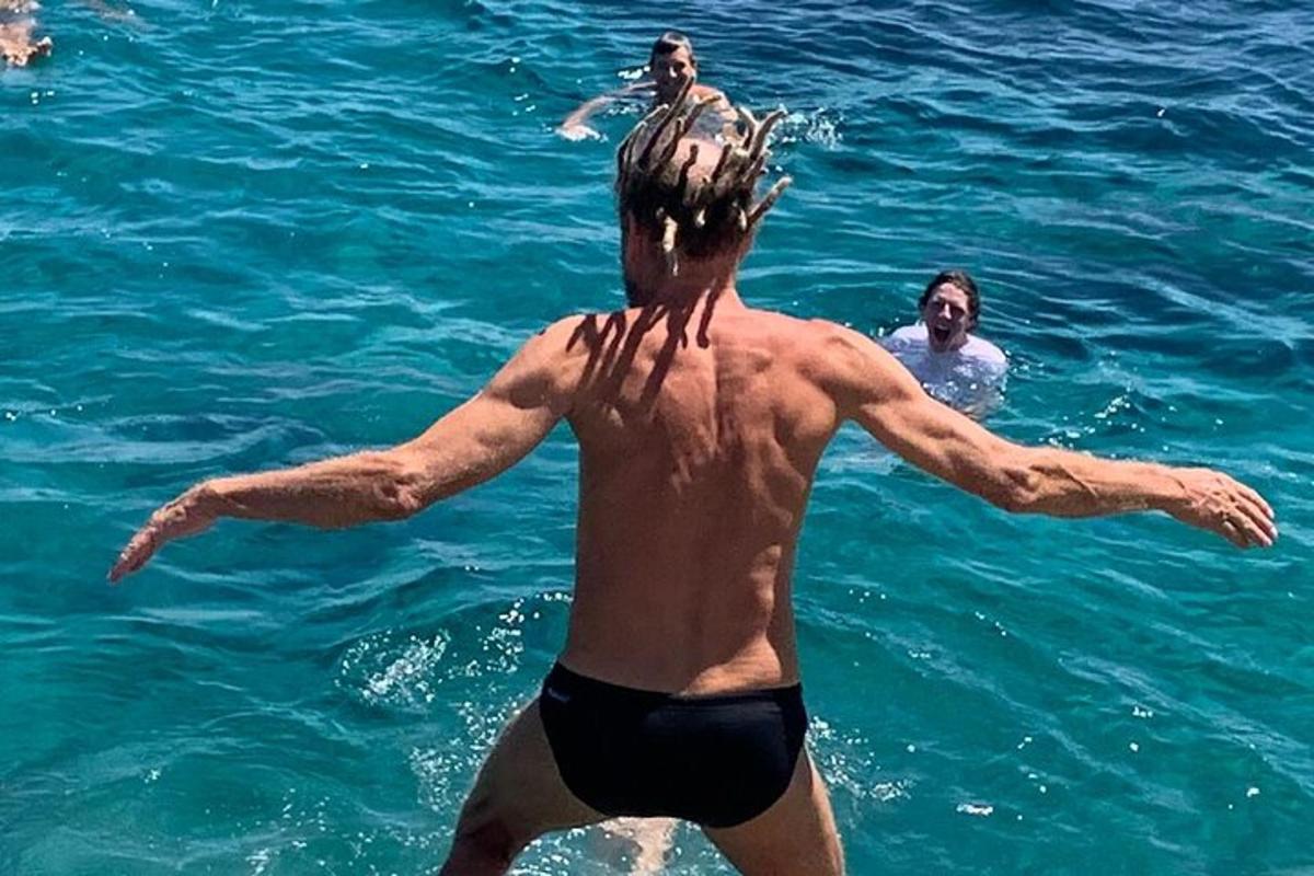un uomo in acqua con un uccello sulla schiena