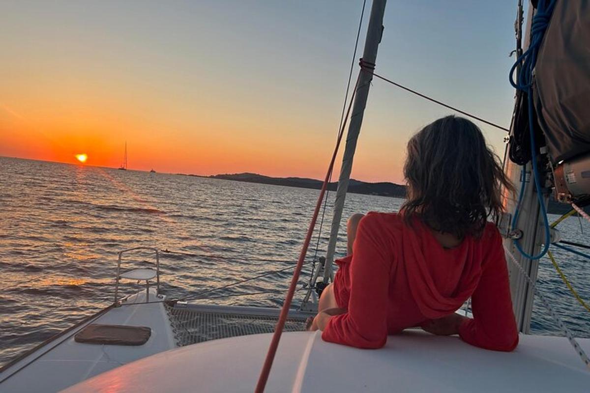 una donna seduta su una barca che guarda il tramonto