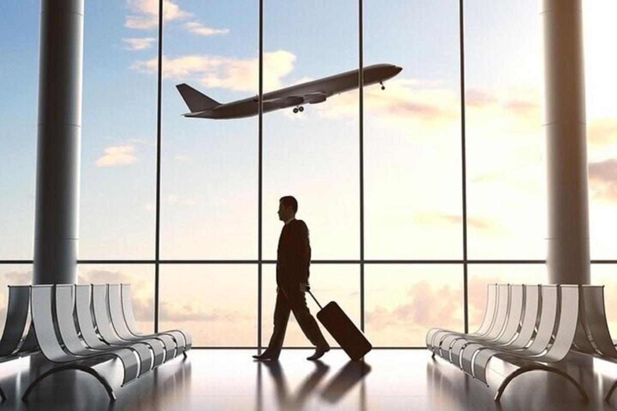 Ein Mann geht durch einen Flughafen und schaut sich ein Flugzeug an