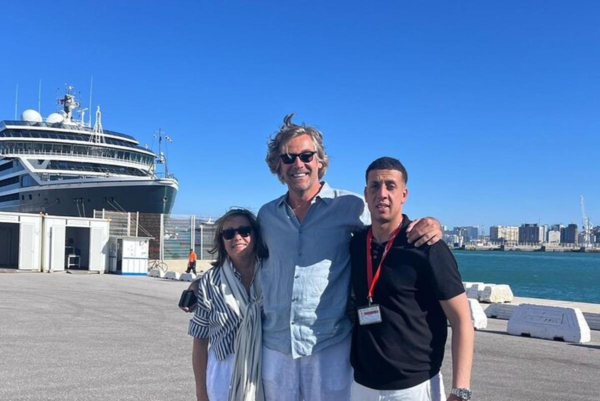 a man and a woman standing next to a cruise ship