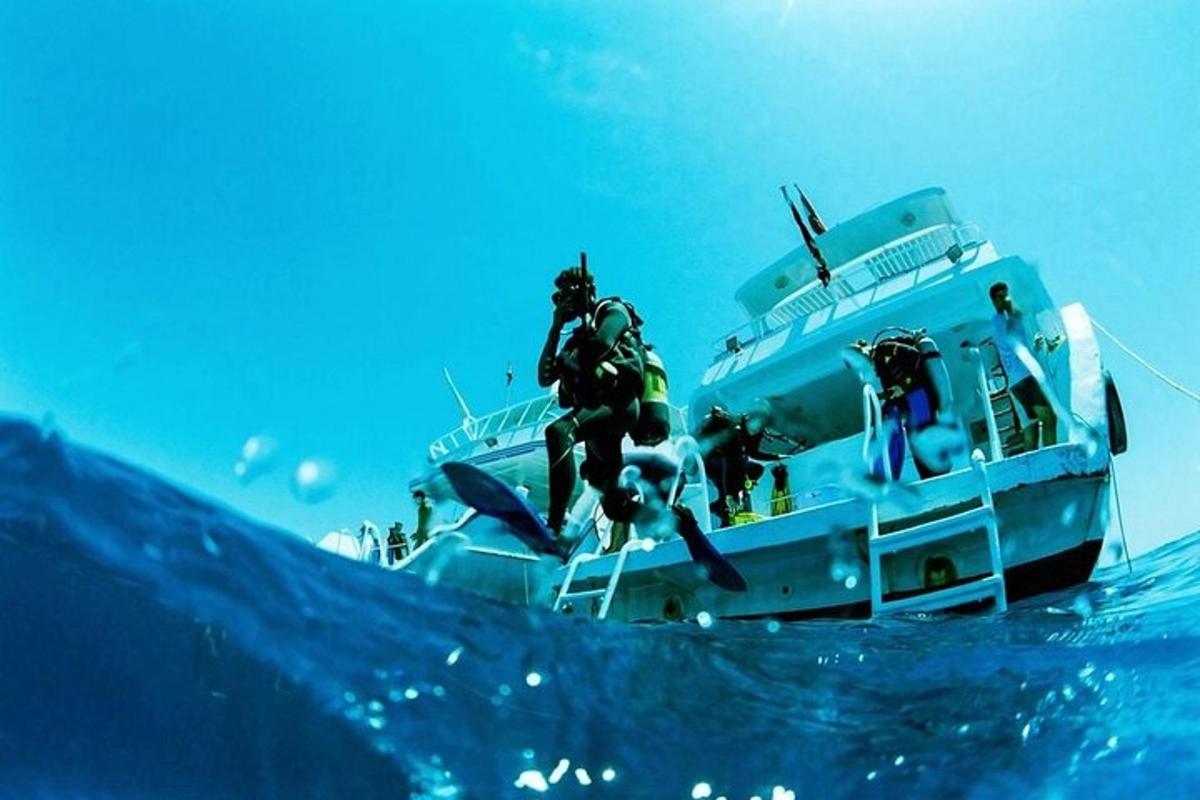 muž skákajúci z lode v oceáne