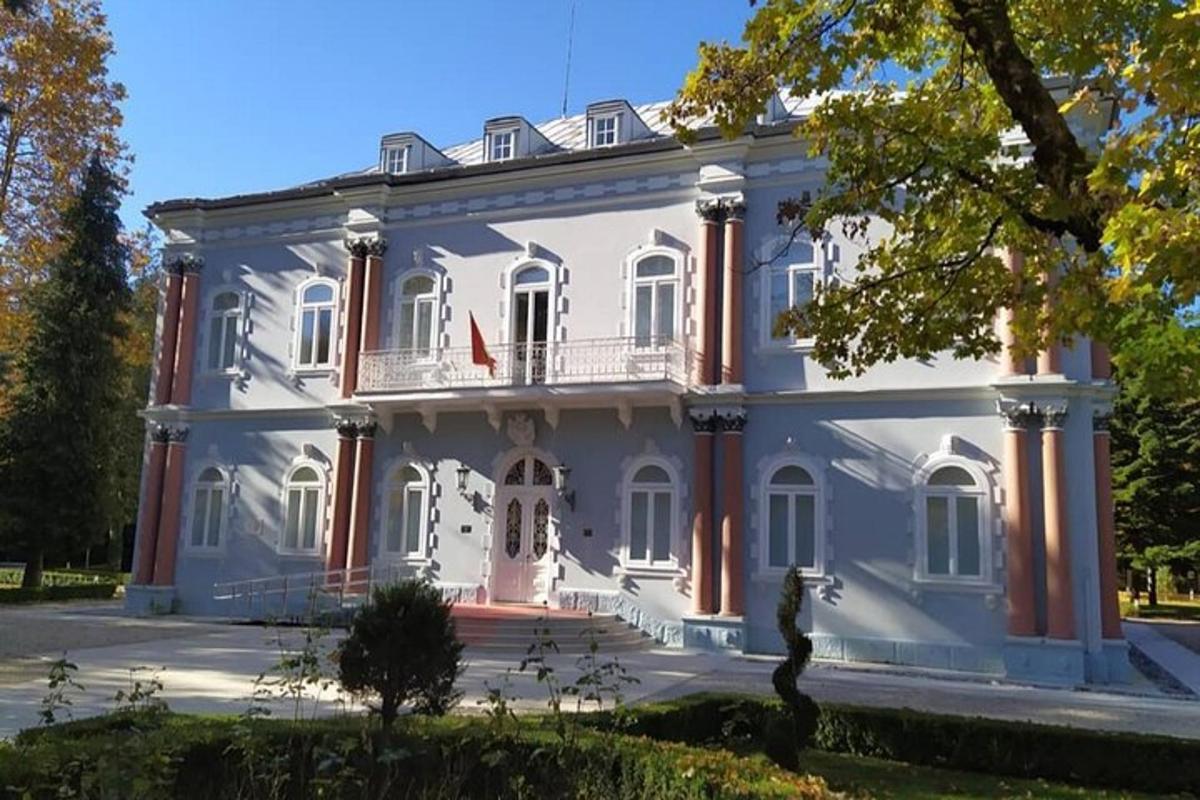 una gran casa blanca amb un balcó al carrer