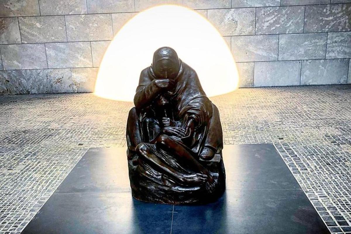 una estatua de bronce de un hombre sentado en el suelo