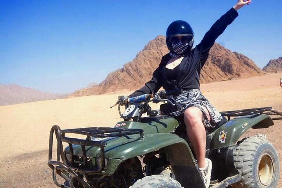 seseorang yang duduk di atas atv di padang pasir