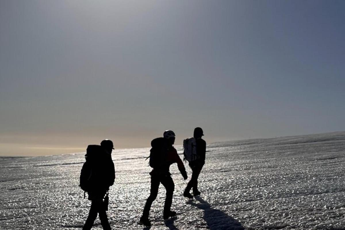 un gruppo di tre persone che camminano attraverso un campo coperto di neve