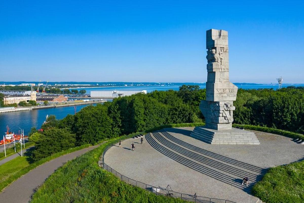um monumento no topo de uma colina ao lado de um rio