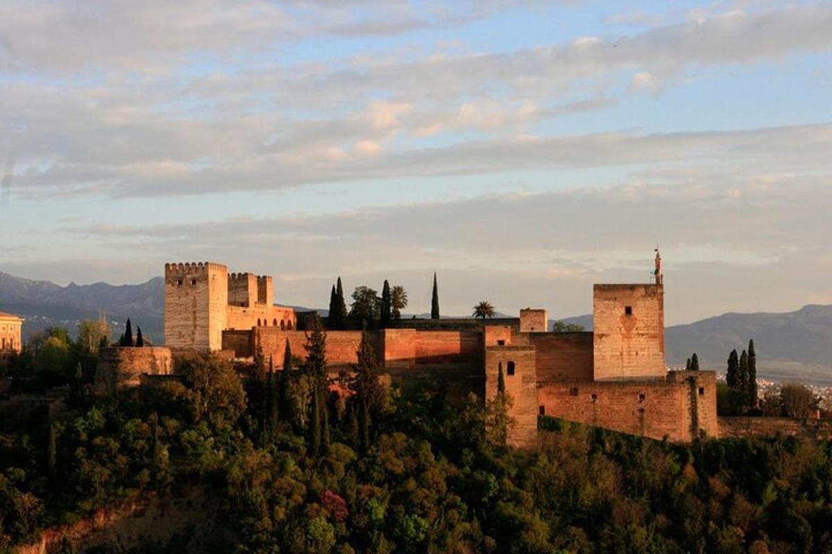 a castle on top of a hill with mountains in the background