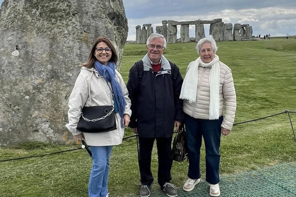 tre persone in piedi davanti a un monumento di pietra