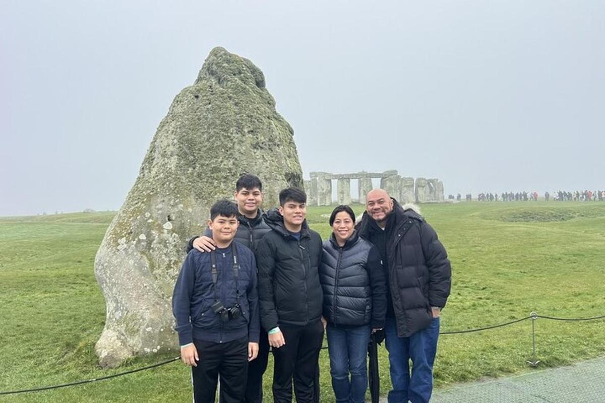 un gruppo di persone in piedi davanti a una roccia
