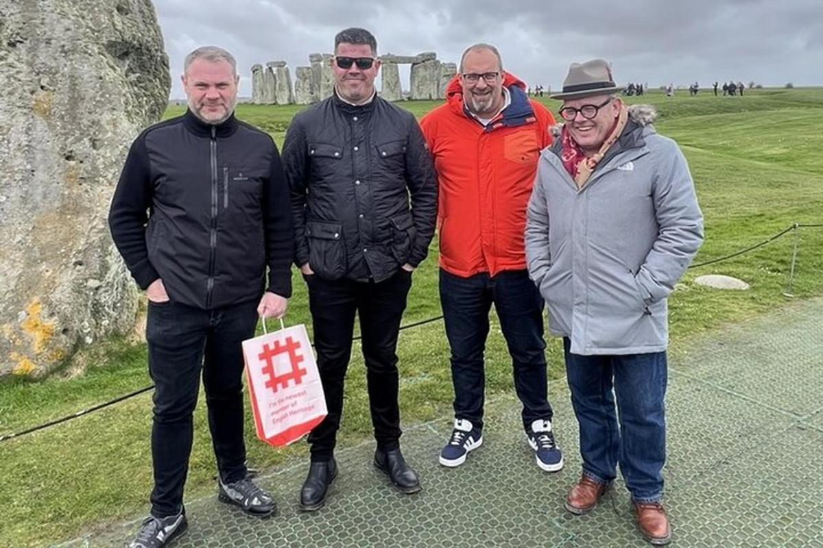 en gruppe på tre menn som poserer for et bilde på en golfbane