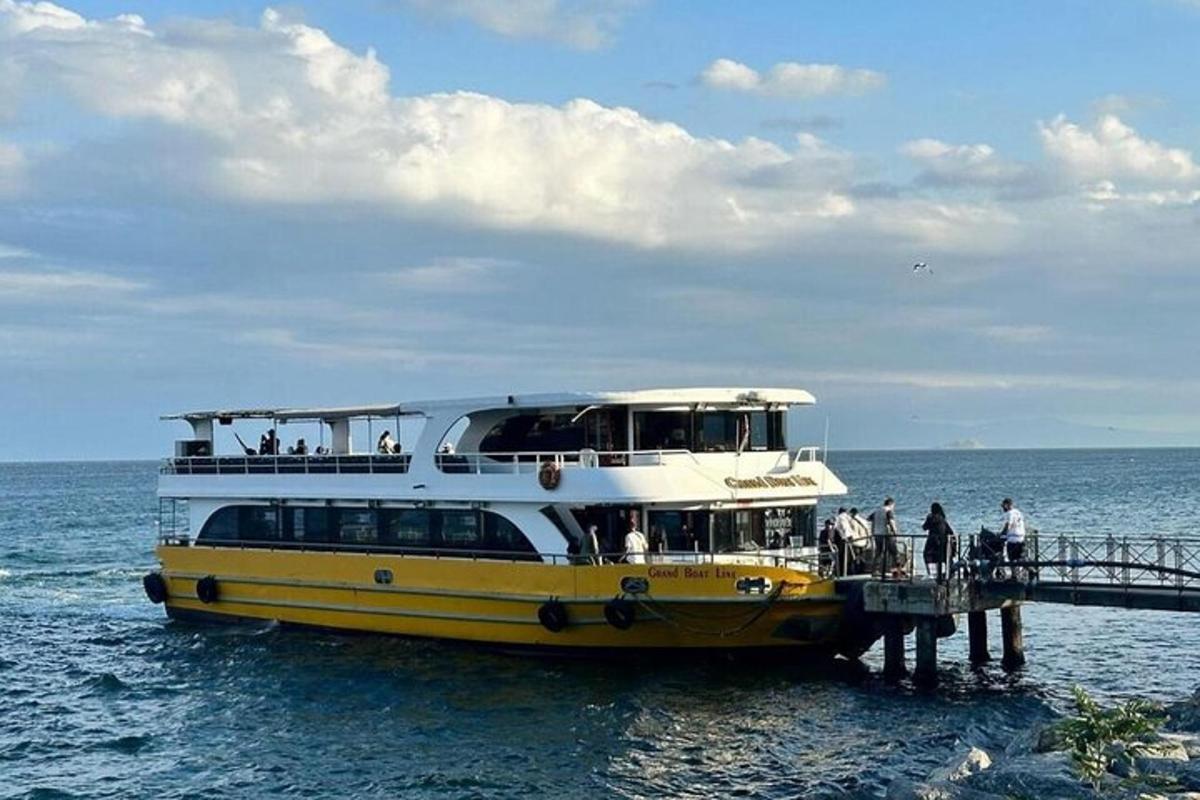 a yellow and white boat on the water next to a pier