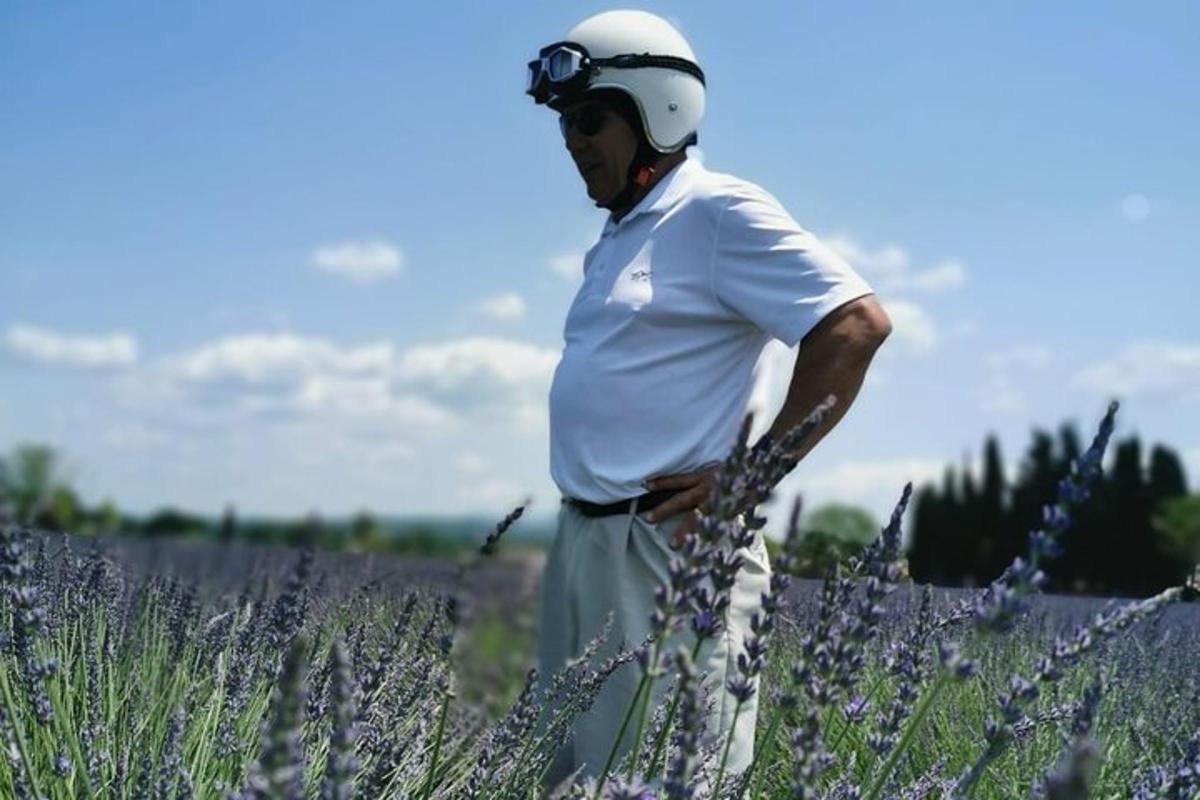 Un hombre con casco de pie en un campo de lavanda.