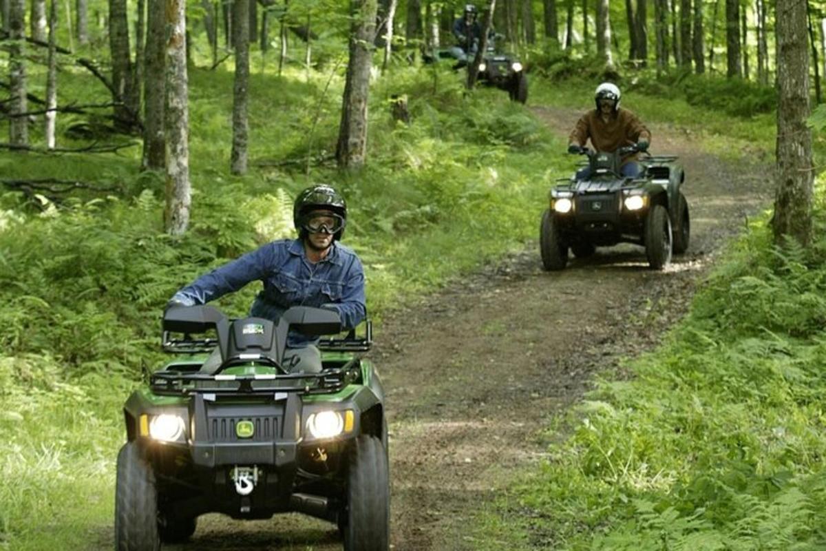 Δύο άτομα οδηγούν σε ATV σε χωματόδρομο