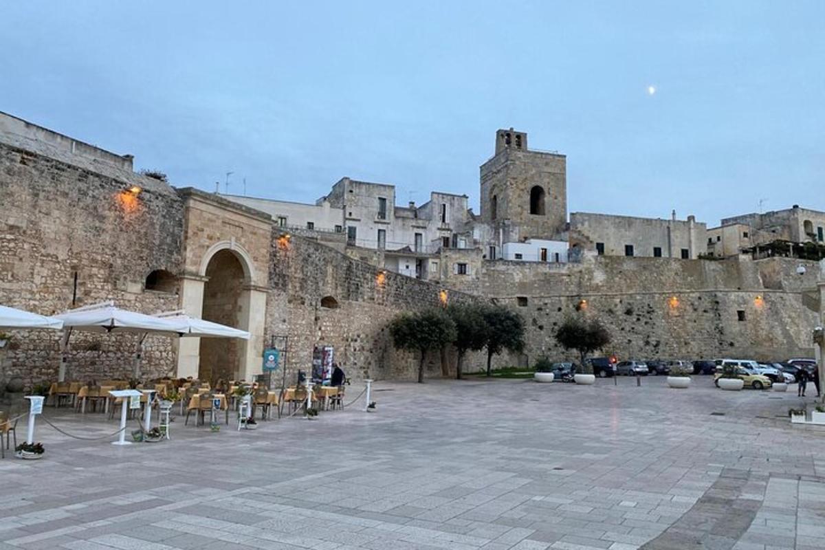 μια αυλή μπροστά από ένα κάστρο με τραπέζια και ομπρέλες