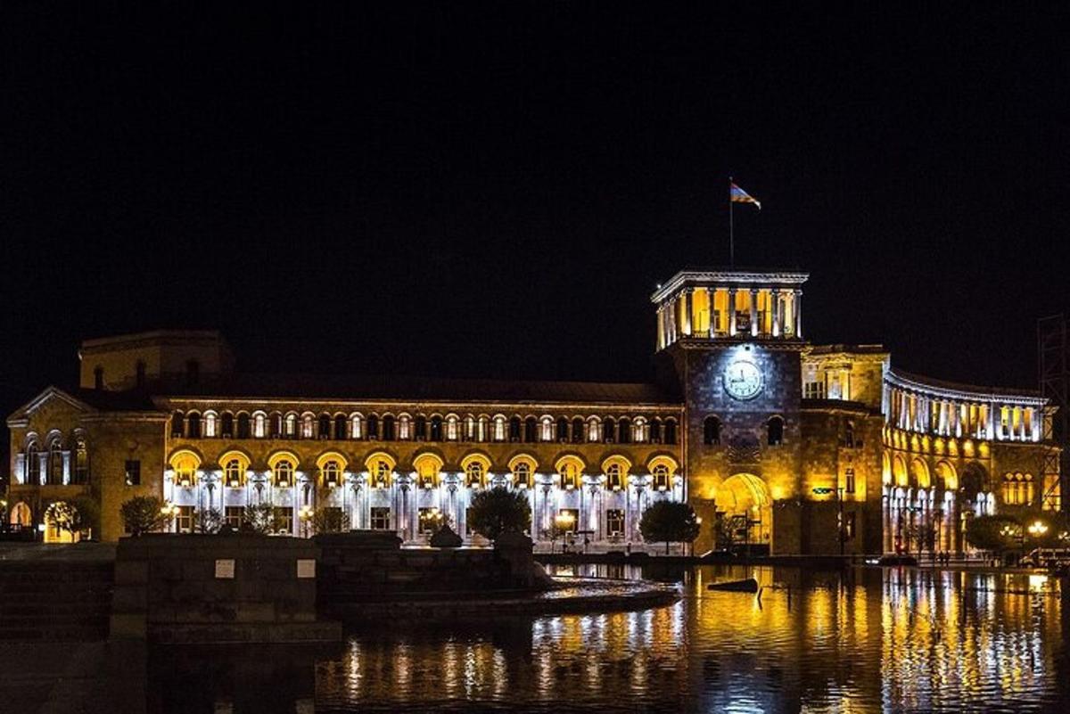 um grande edifício com uma torre do relógio à noite