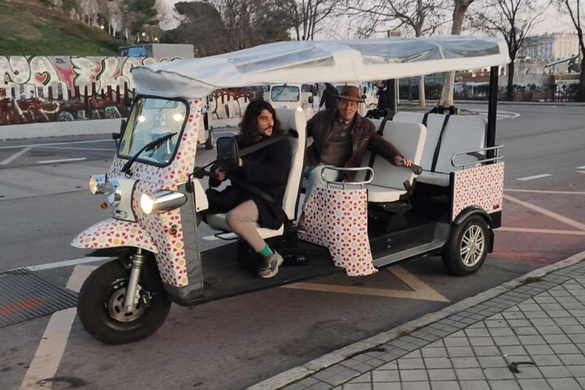 muž a žena sedící v golfovém vozíku