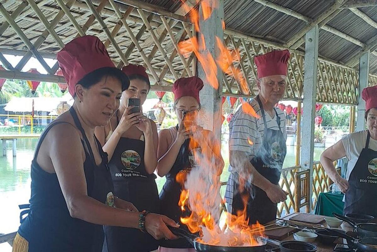 egy csoport ember áll egy tűz melletti grillsütő körül