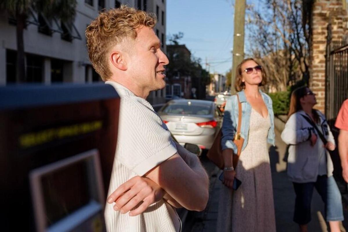 a man standing on the street looking at a computer