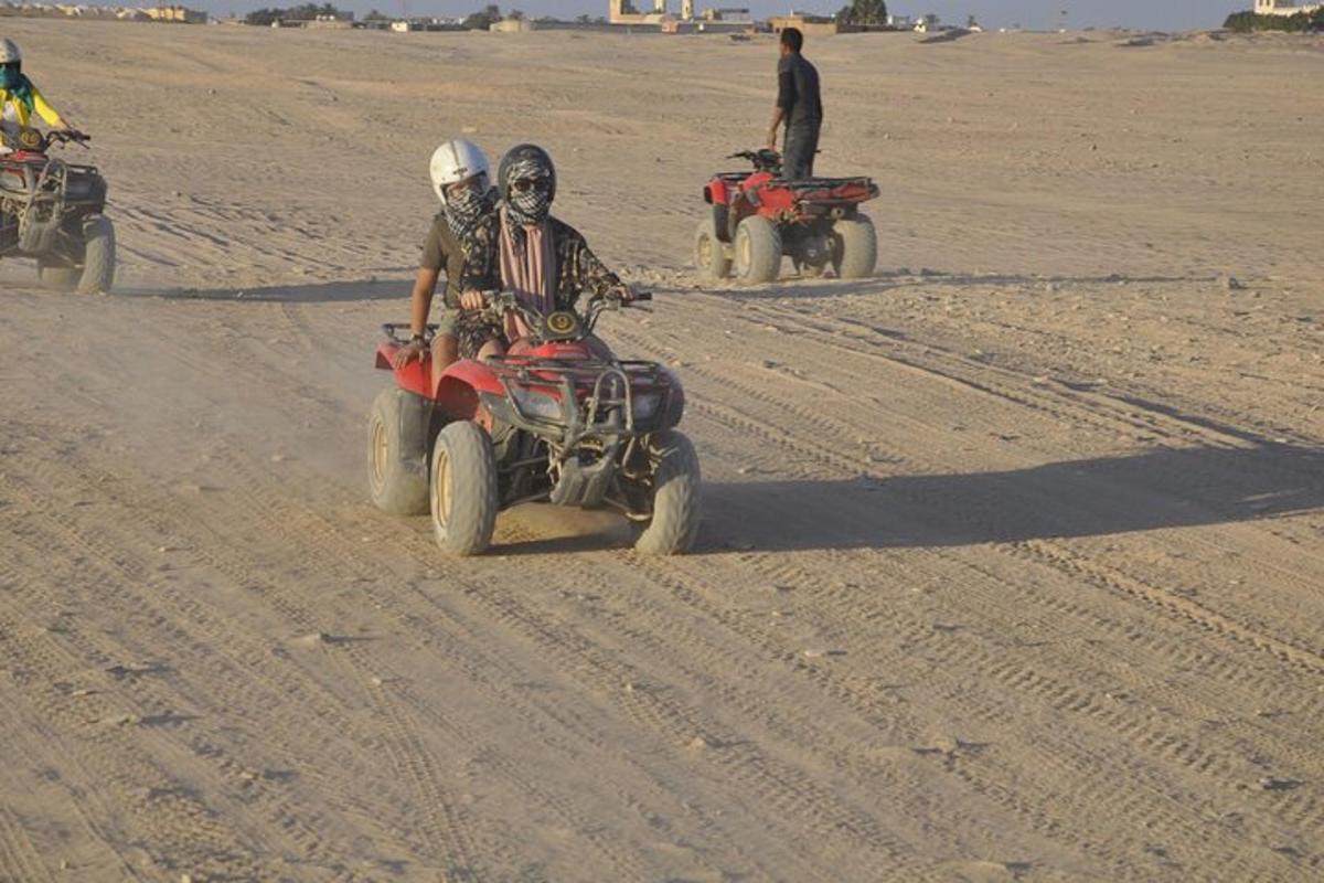 um grupo de pessoas andando de quadriciclo no deserto