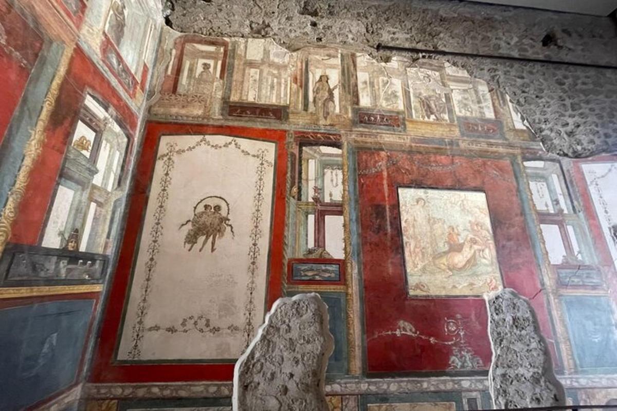 Una habitación con un montón de cuadros en una pared.
