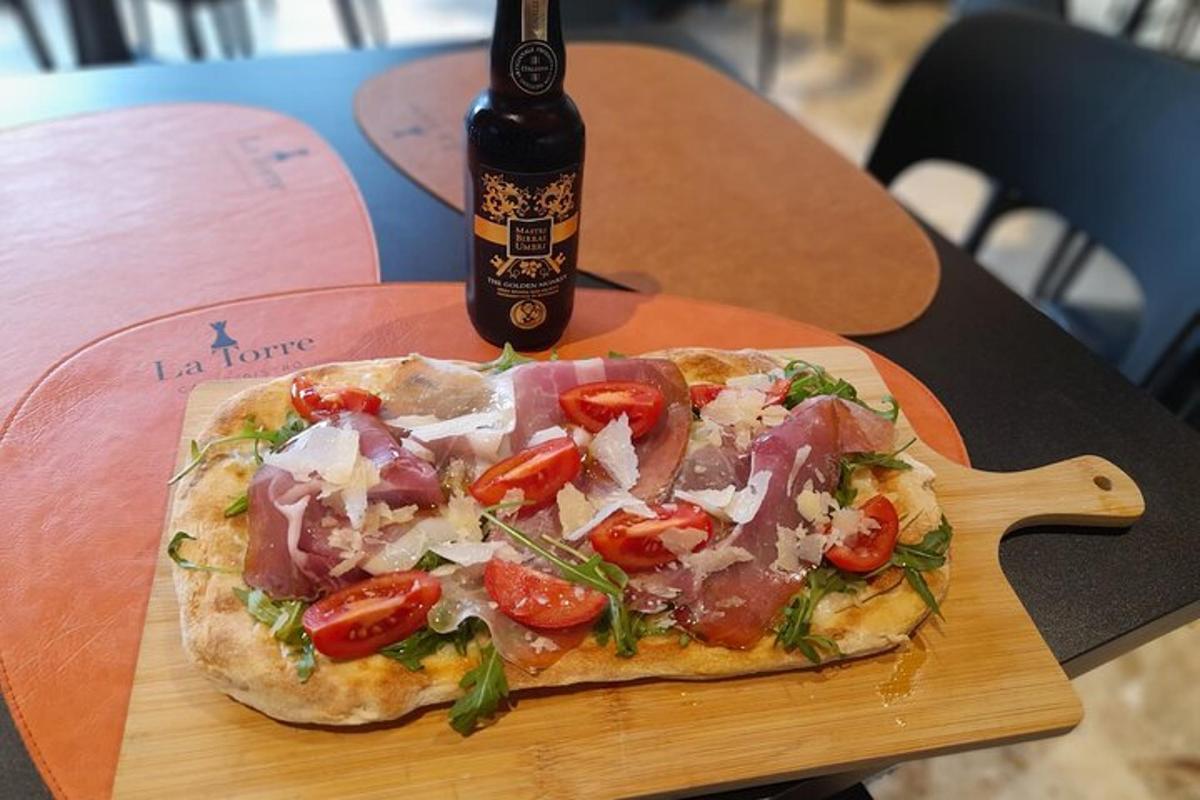 a pizza on a wooden cutting board with a bottle of beer