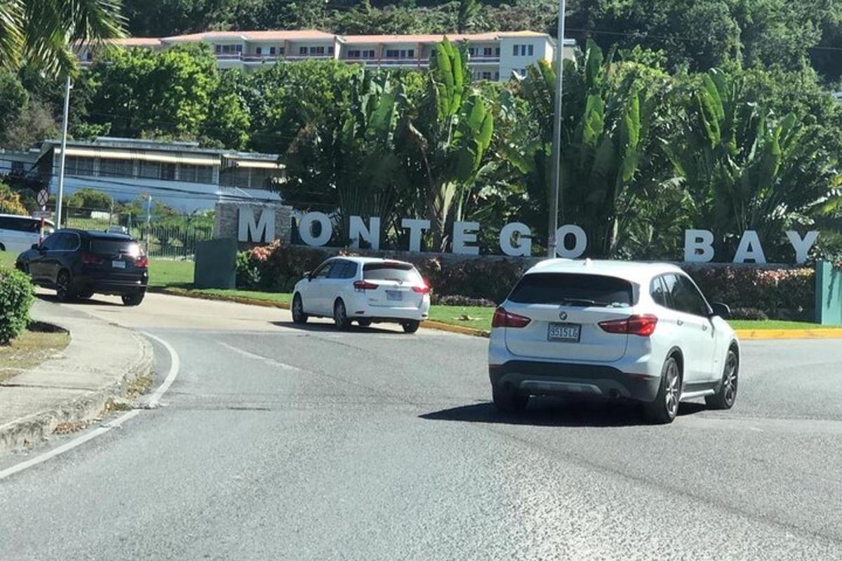 due auto stanno percorrendo una strada con un cartello