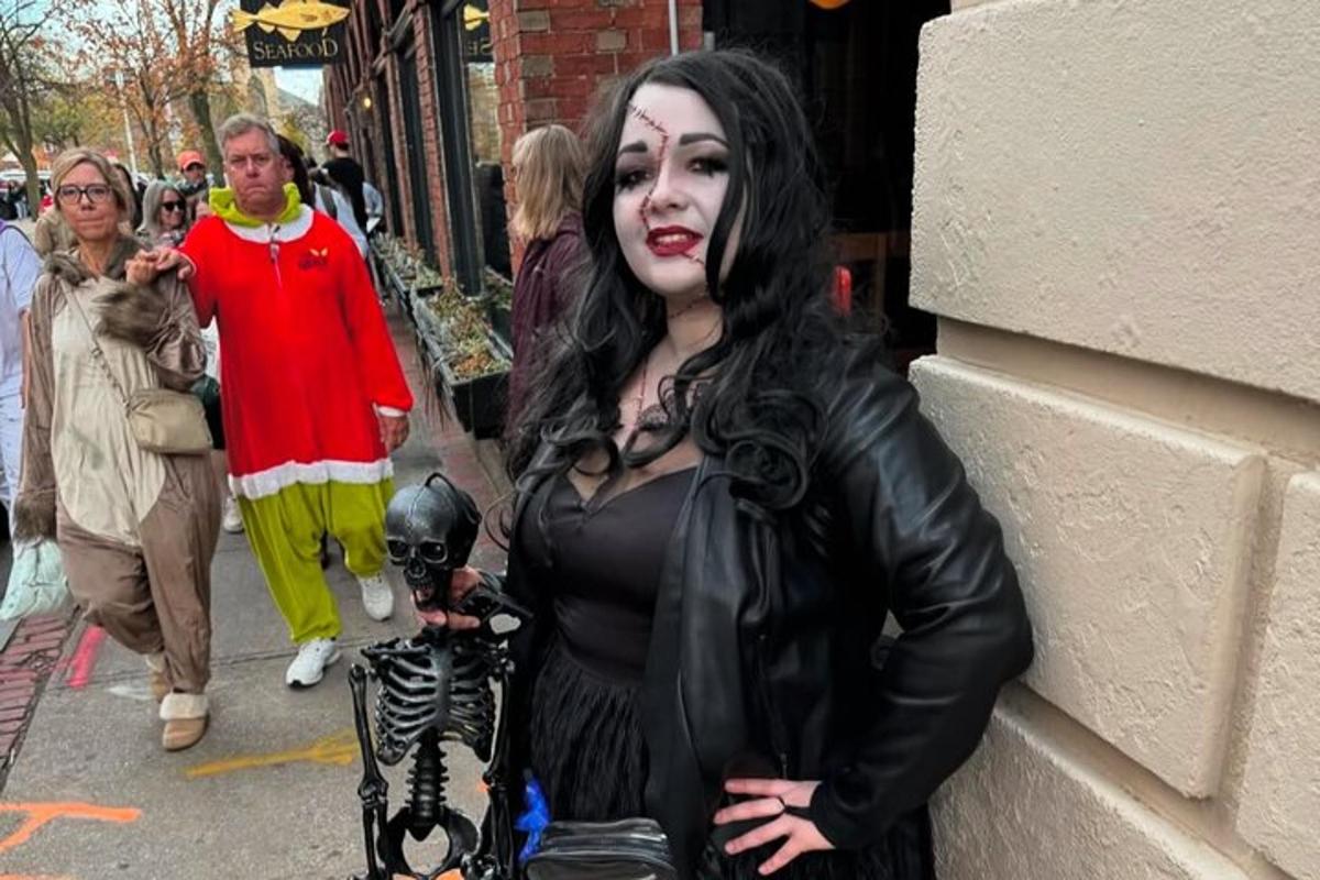 uma mulher vestida com uma fantasia de esqueleto em uma rua