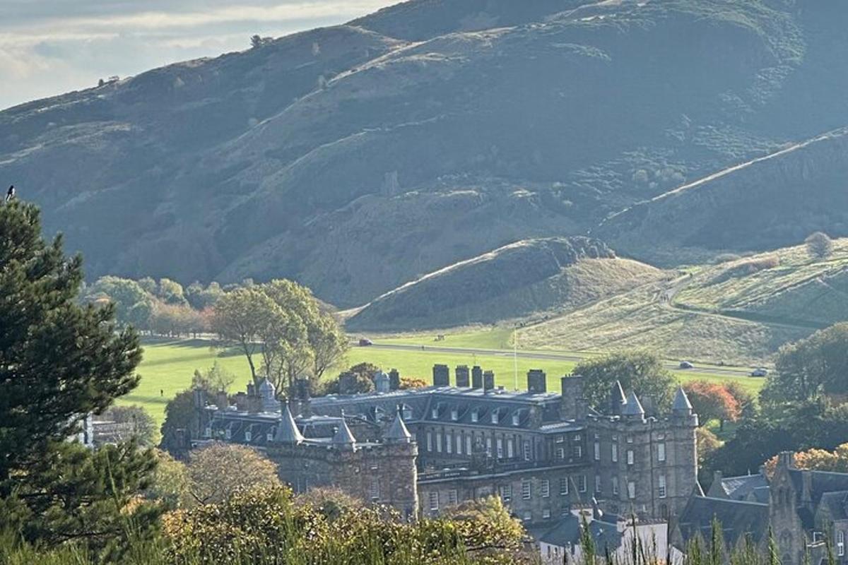 a large castle in a valley with mountains in the background