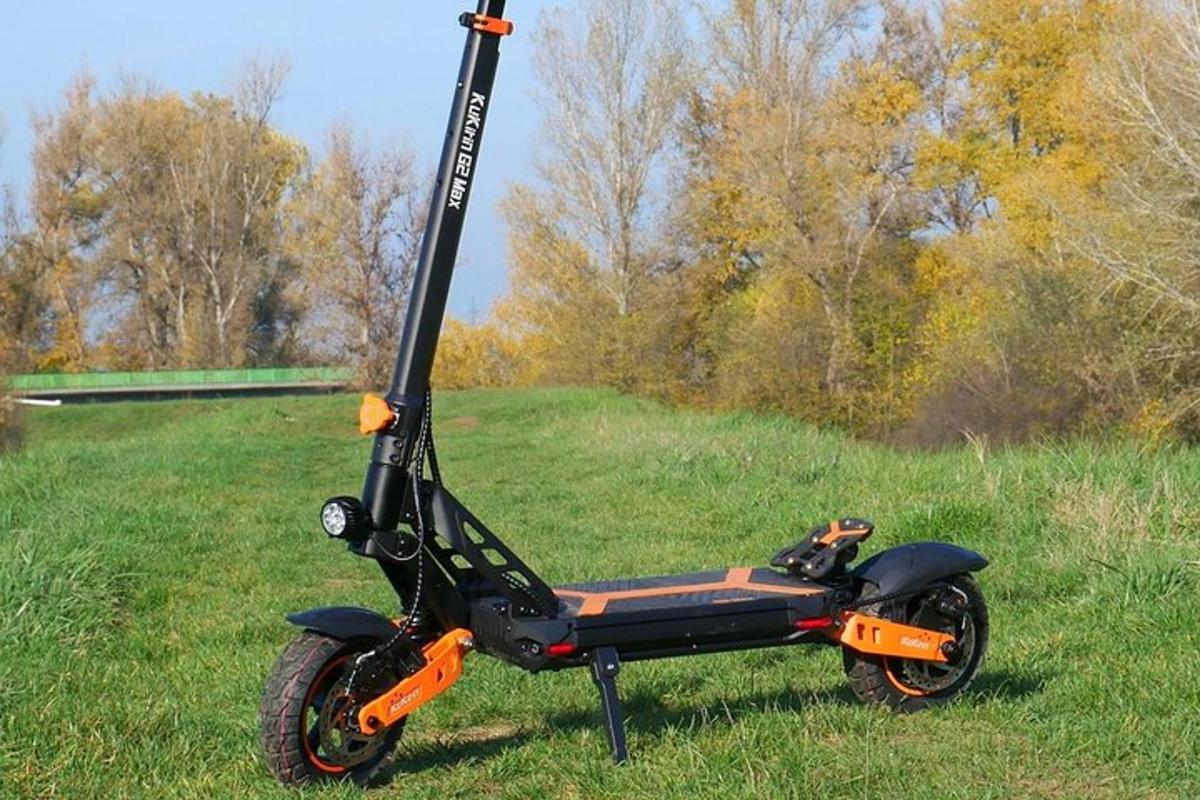 a black and orange scooter parked in a field