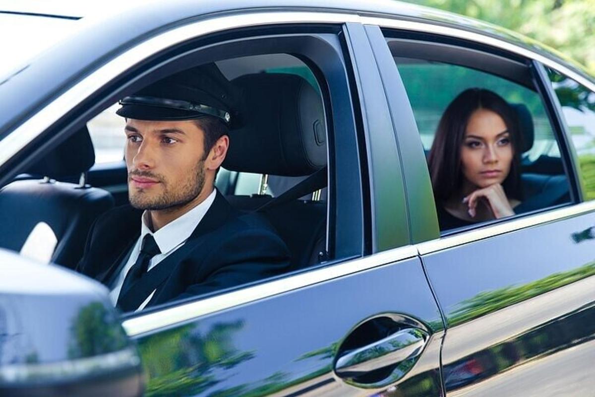 a man in a uniform sitting in a car with a woman