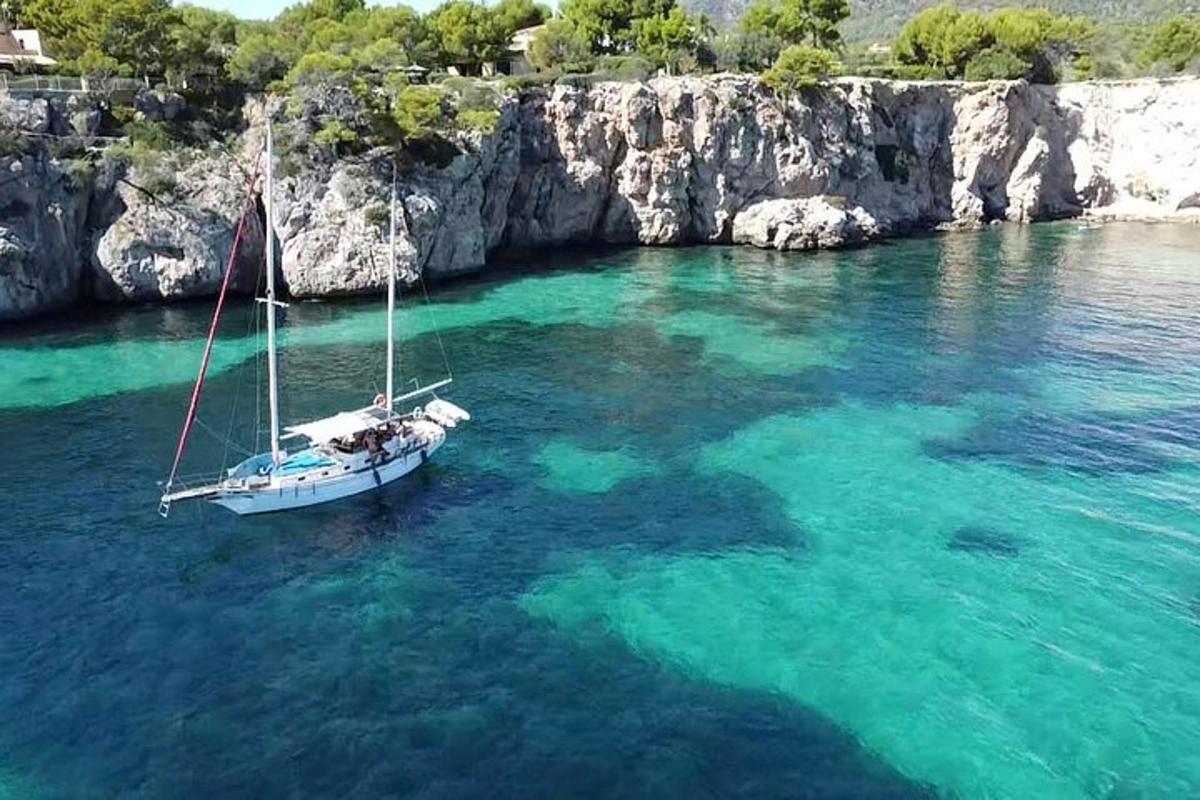 μια βάρκα στο νερό δίπλα σε έναν απότομο βράχο